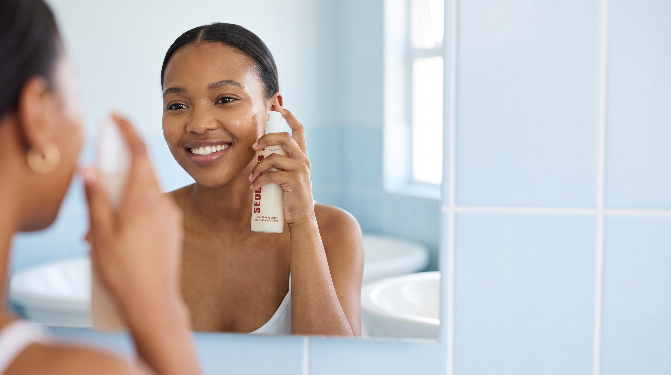 Young South African woman with healthy balanced skin using an essence in a simple everyday routine