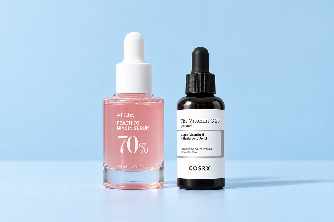 Anua Peach 70 Niacin Serum and COSRX The Vitamin C 23 Serum on a pale blue background